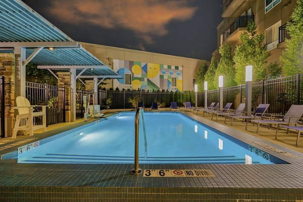 Stylish swimming pool area with lounge chairs and a vibrant mural at luxury apartments