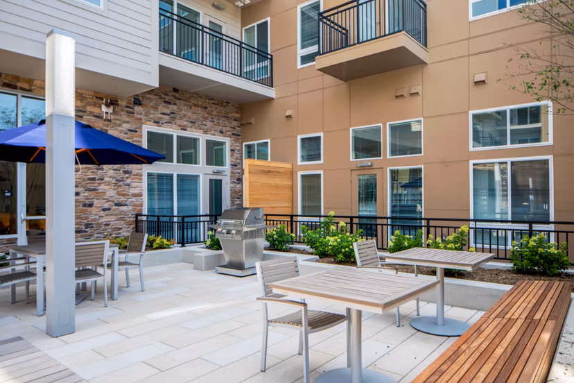 Outdoor grill area with modern seating arrangements at Loren Apartments, a luxury living community offering exceptional amenities