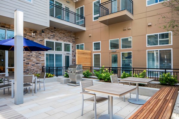 Outdoor grill area with modern seating arrangements at Loren Apartments, a luxury living community offering exceptional amenities