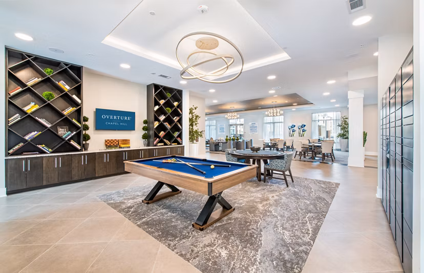 Game room with pool table and lounge seating at Overture Chapel Hill Apartments, a luxury community offering vibrant social spaces
