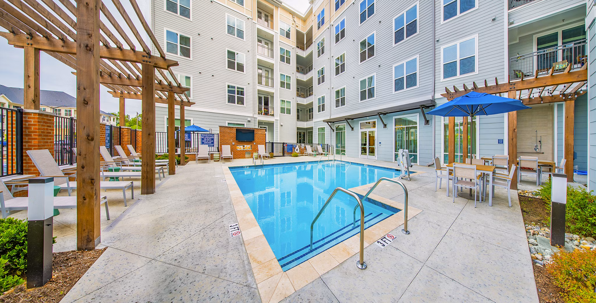 Pool with sun loungers and landscaped surroundings at Overture Chapel Hill Apartments