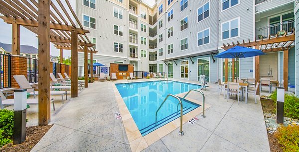 Pool with sun loungers and landscaped surroundings at Overture Chapel Hill Apartments