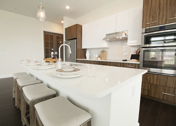 Modern kitchen featuring stainless steel appliances and granite countertops at Amorance Apartments