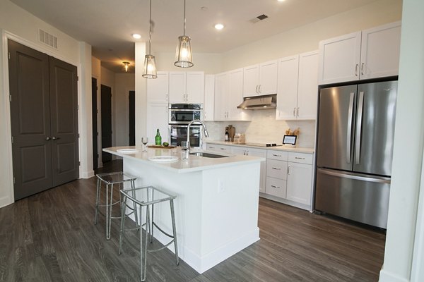 Kitchhttps://s7d9scene7com/is/image/greystarprod/16465KIT6?qlt=86&wid=600en with modern appliances and granite countertops at Amorance Apartments