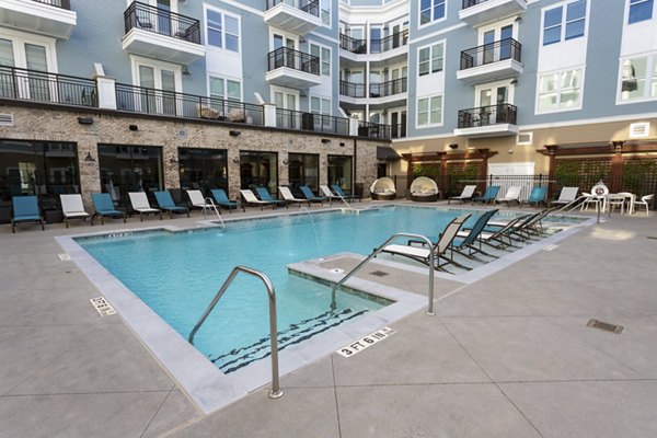 Luxurious pool at Amorance Apartments with modern design and lounge seating in prime location