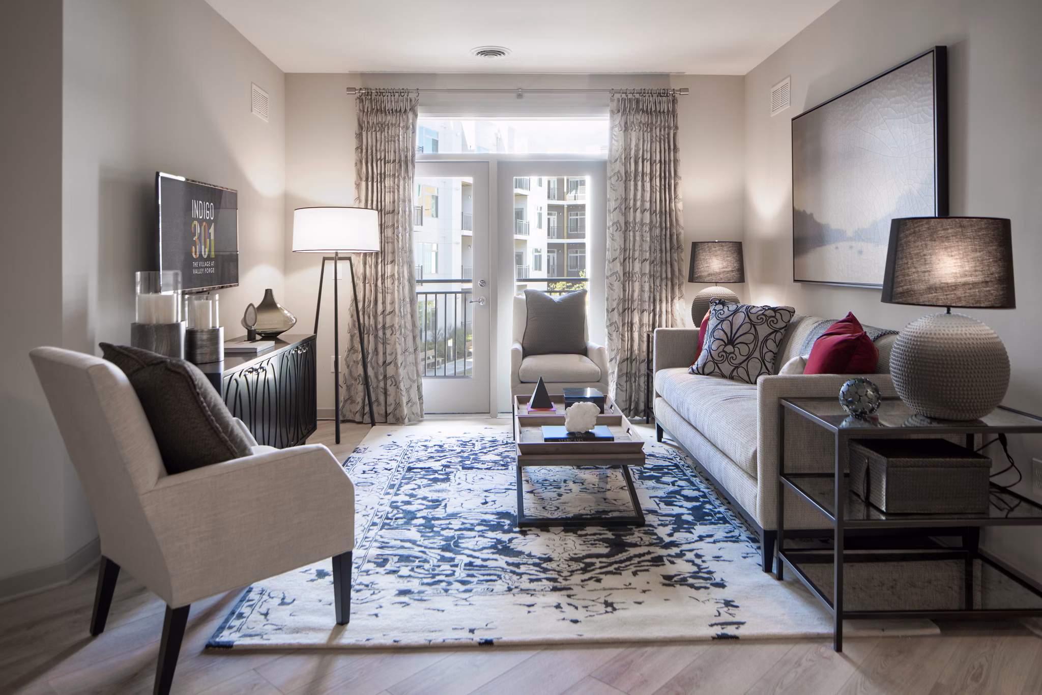 Open concept living room with modern decor and large windows at Indigo 301 Apartments