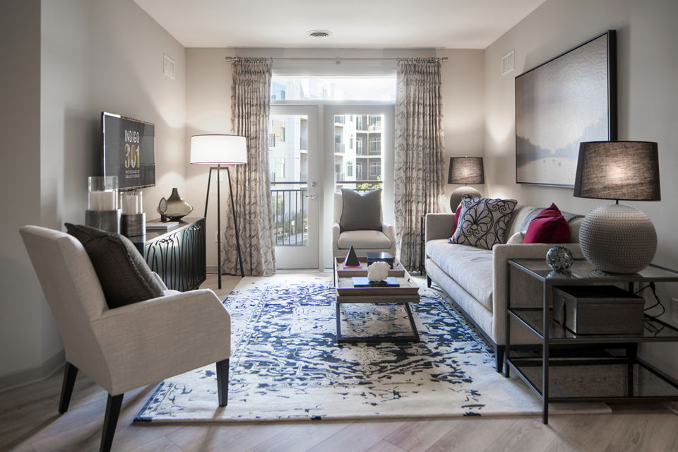 Open concept living room with modern decor and large windows at Indigo 301 Apartments