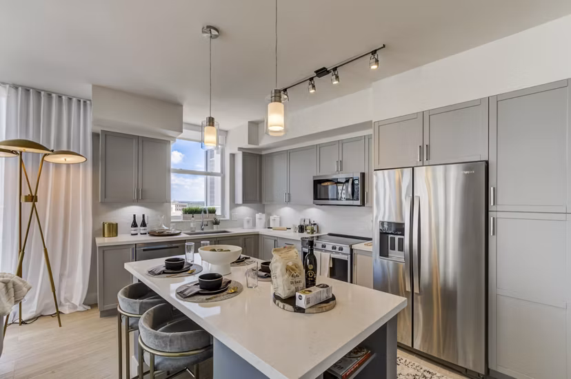 Modern kitchen featuring stainless steel appliances and quartz countertops at Alluvion Las Olas Apartments