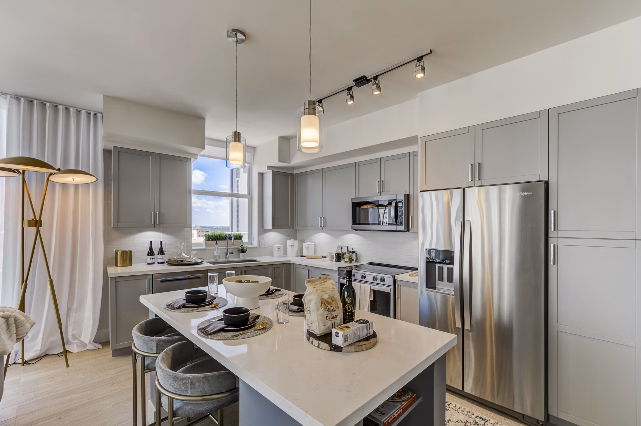 Modern kitchen featuring stainless steel appliances and quartz countertops at Alluvion Las Olas Apartments