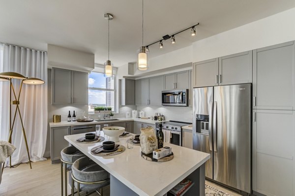 Modern kitchen featuring stainless steel appliances and quartz countertops at Alluvion Las Olas Apartments