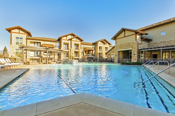 Inviting outdoor pool at The Preserve luxury apartments with lounge chairs and lush landscaping, perfect for relaxation and recreation