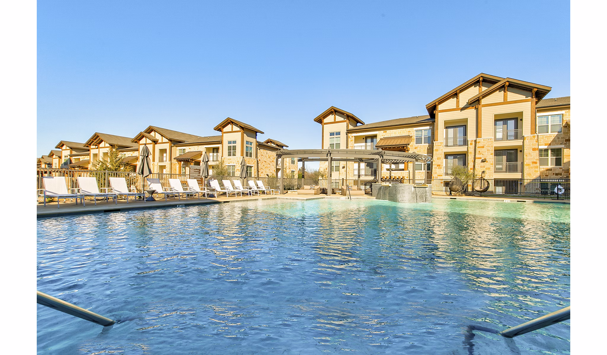 Outdoor swimming pool with lounge chairs at The Preserve, luxury apartments
