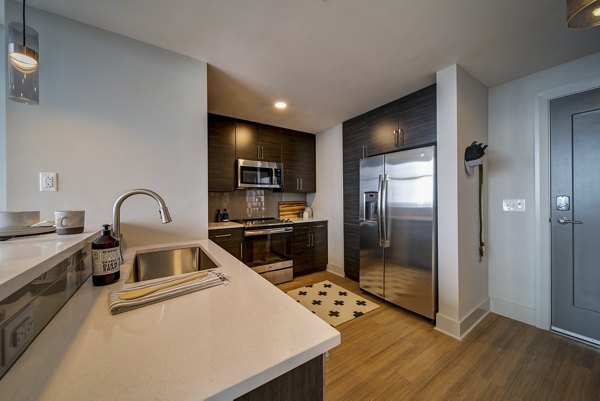 Stylish kitchen with modern appliances at 511 Faye Apartments, luxury living with Greystar quality amenities and design