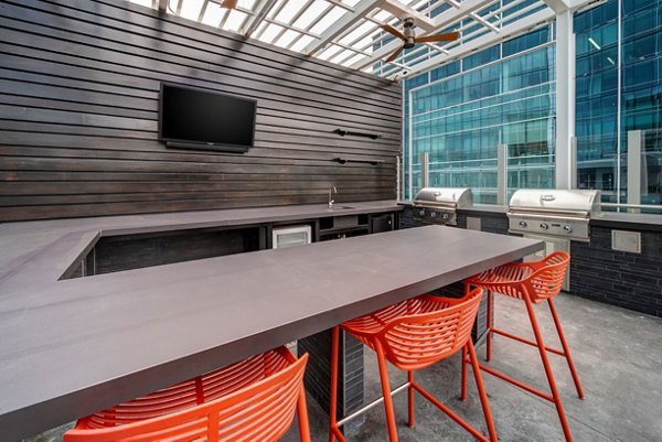 Grill area with modern seating at 511 Faye Apartments, a luxury community offering stylish outdoor amenities