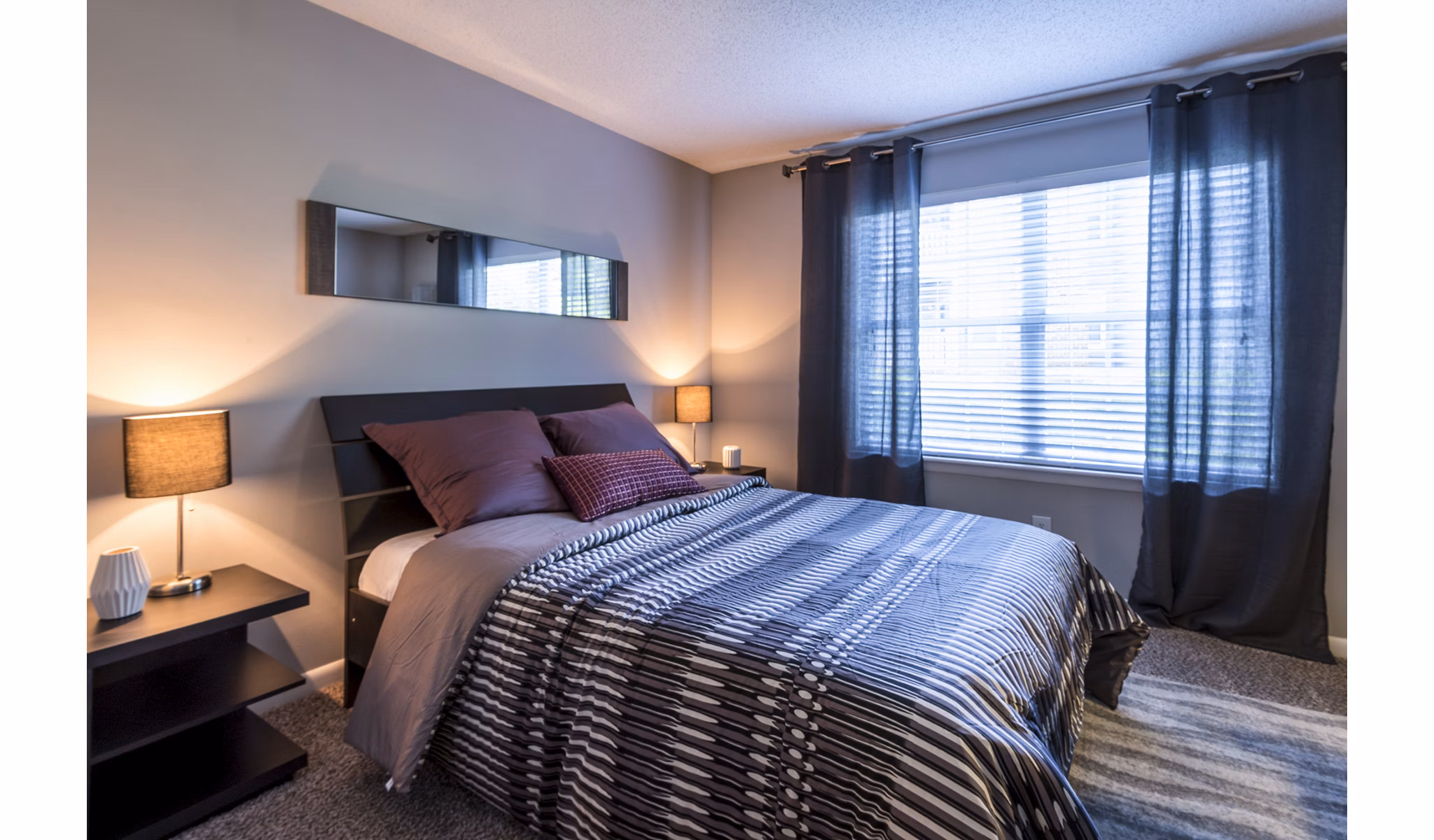 Comfortable bedroom with modern decor and large windows at Bridgeport Apartments