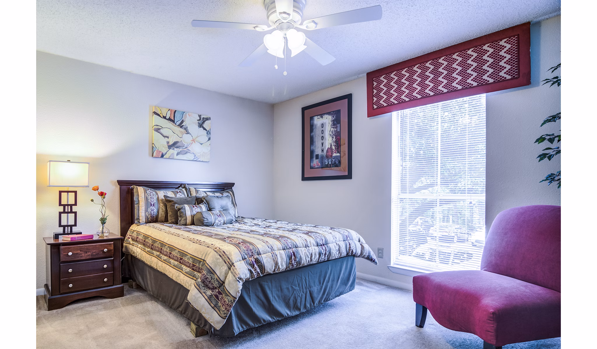 Bedroom with elegant furnishings and large windows in Avana Cumberland Apartments