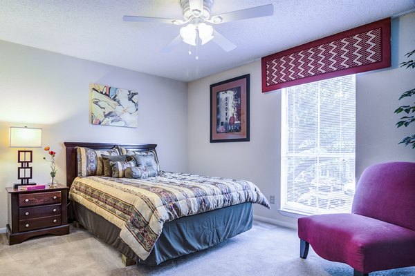Bedroom with elegant furnishings and large windows in Avana Cumberland Apartments