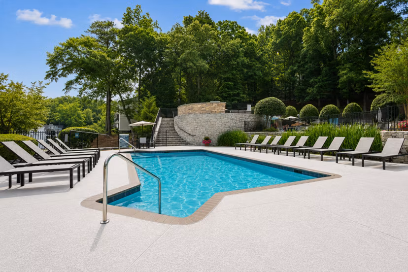 Resort-style pool at Avana Cumberland Apartments, luxury living with sun loungers and greenery for relaxation