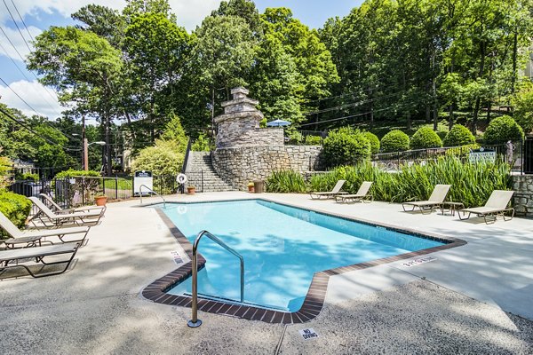Resort-style pool at Avana Cumberland Apartments, luxury living with sun loungers and greenery for relaxation