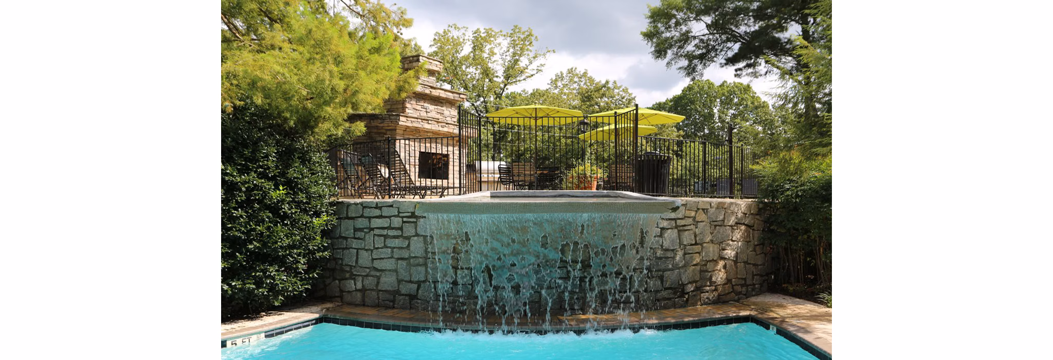 Inviting pool area at Avana Cumberland Apartments with lounge chairs and vibrant landscaping, ideal for relaxation and social gatherings