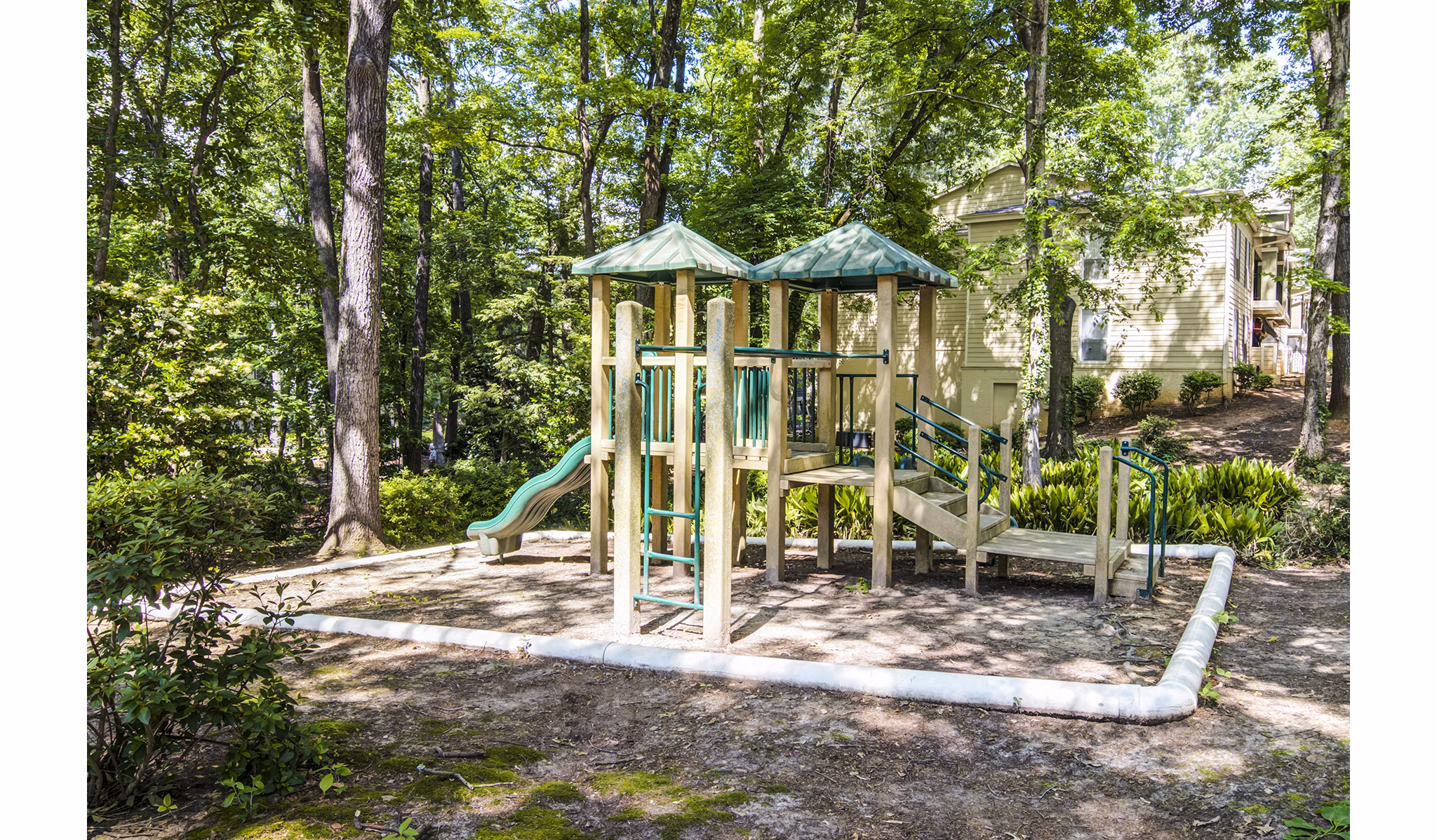 Spacious playground with slides and swings at Avana Cumberland Apartments, ideal for family fun and outdoor activities