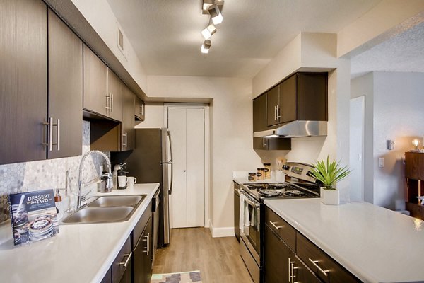 Modern kitchen featuring granite countertops and stainless steel appliances at Tuscan Heights Apartments, a luxury Greystar community