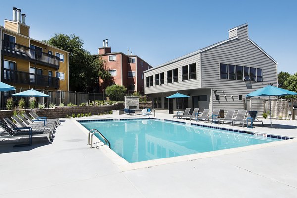 Resort-style pool at Tuscan Heights Apartments with lounge chairs and lush landscaping