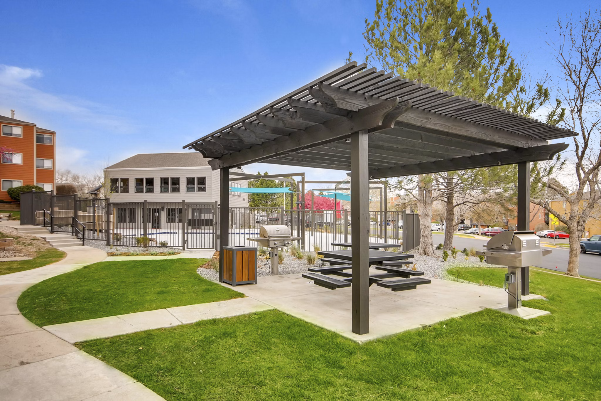 Spacious outdoor grill area with modern seating at Tuscan Heights Apartments, perfect for social gatherings and dining