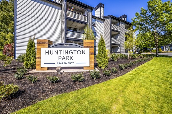 Huntington Park Apartments: Signage showcasing entrance to luxury living in a serene community setting