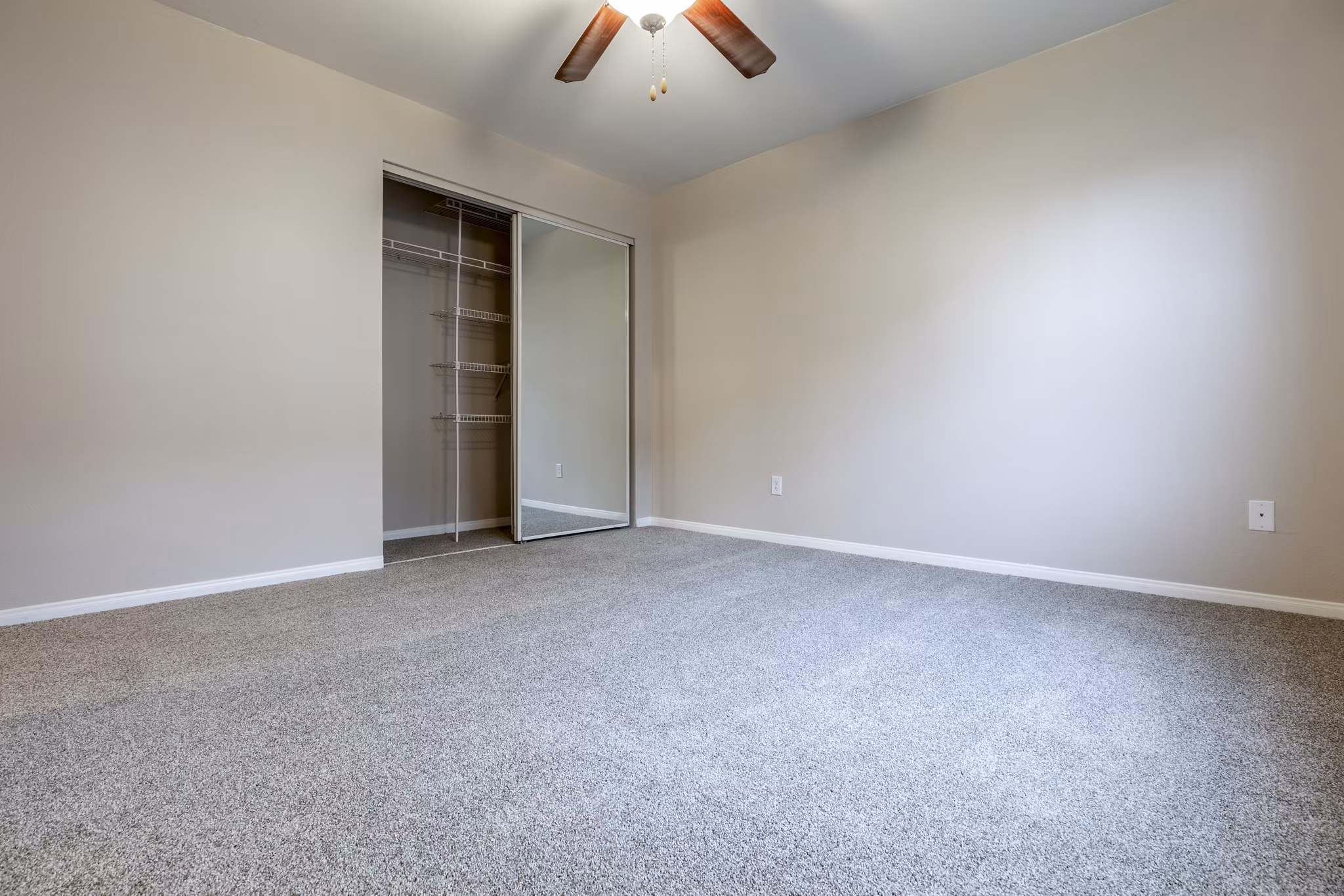 Modern bedroom with stylish decor and large window at Huntington Park Apartments
