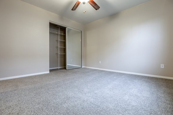 Modern bedroom with stylish decor and large window at Huntington Park Apartments
