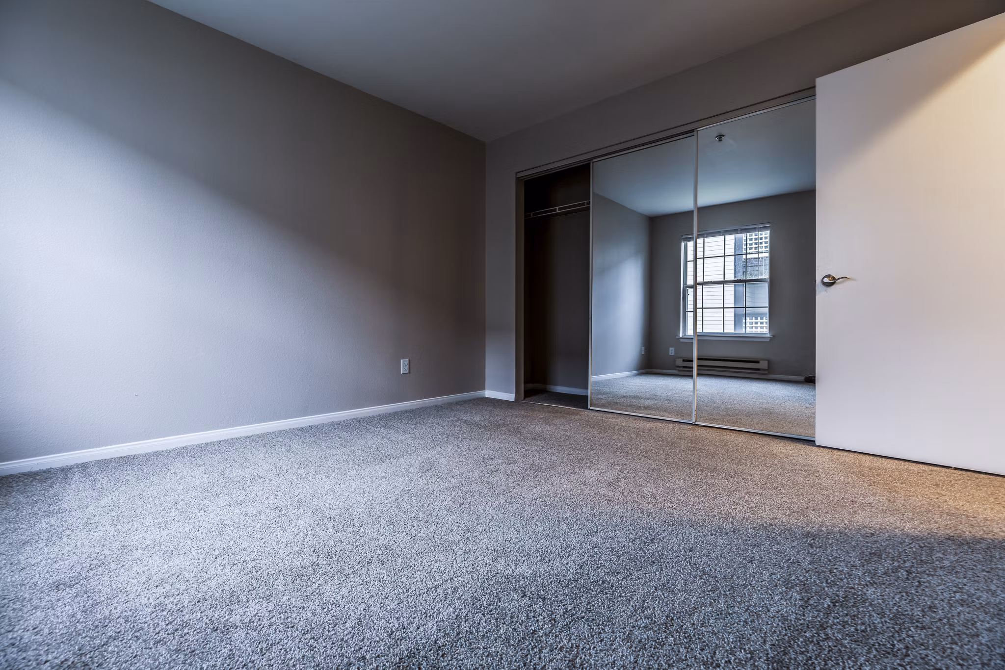 Modern bedroom featuring elegant decor and large windows at Huntington Park Apartments