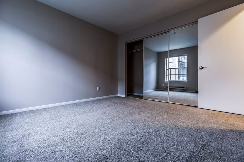Modern bedroom featuring elegant decor and large windows at Huntington Park Apartments