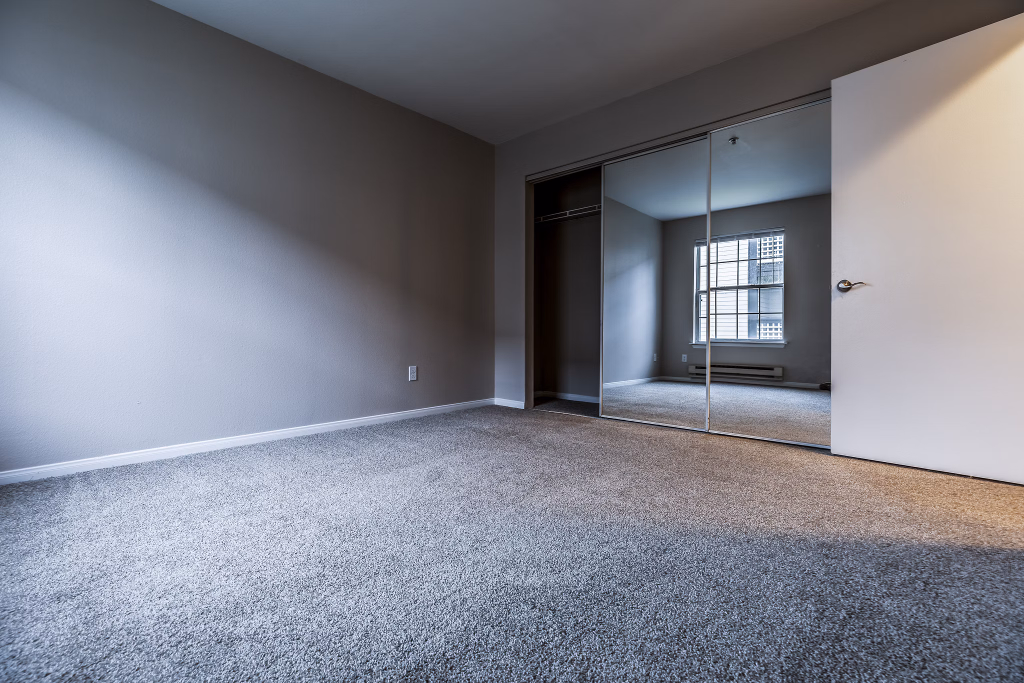 Modern bedroom featuring elegant decor and large windows at Huntington Park Apartments