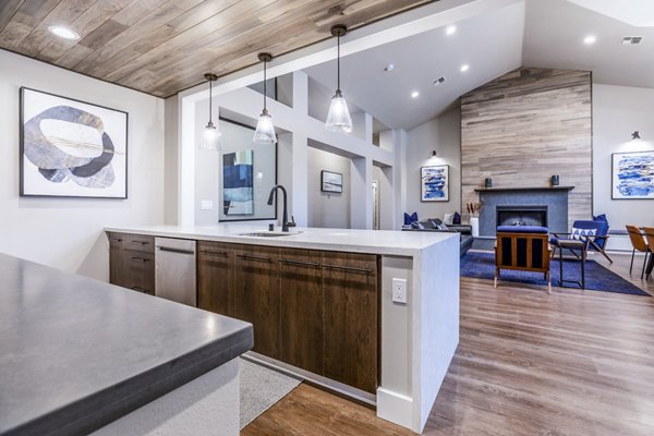 Clubhouse kitchen with modern appliances and island seating at Huntington Park Apartments