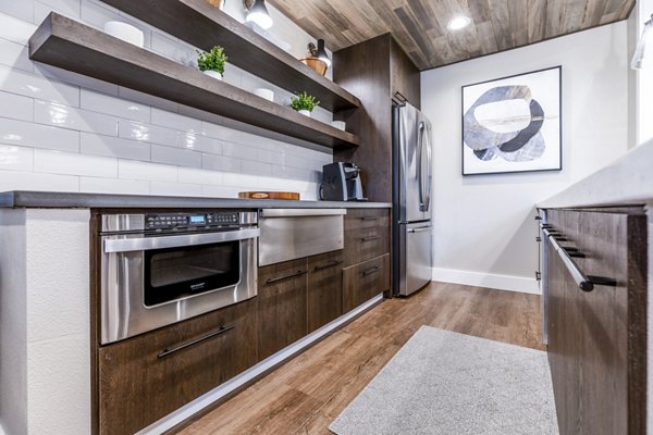 Clubhouse kitchen with modern appliances and island seating at Huntington Park Apartments