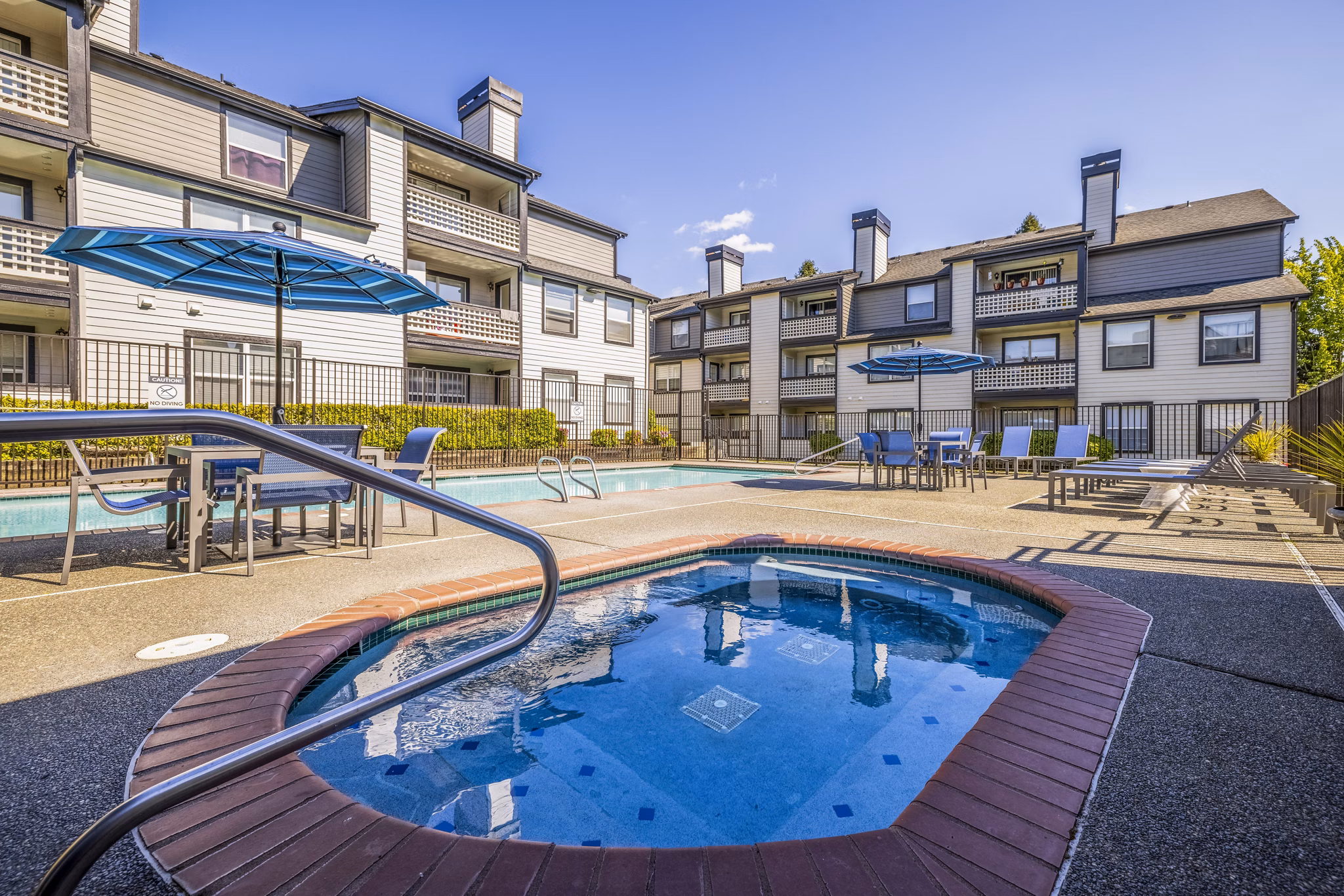 Huntington Park Apartments: Relaxing hot tub at luxury community with lush landscaping