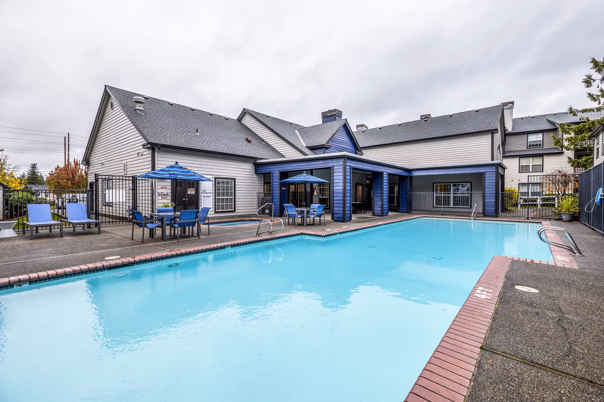 Resort-style pool surrounded by lush greenery at Huntington Park Apartments