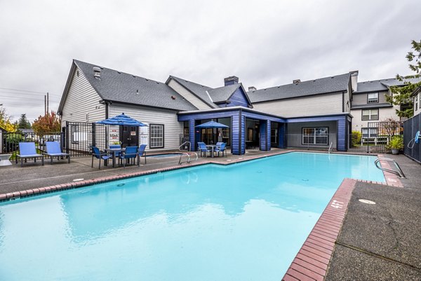 Resort-style pool surrounded by lush greenery at Huntington Park Apartments