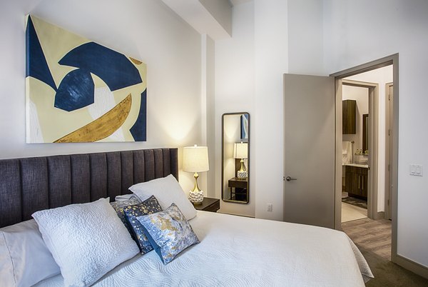 Bedroom with elegant decor and large windows at Raleigh at Sloans Lake Apartments