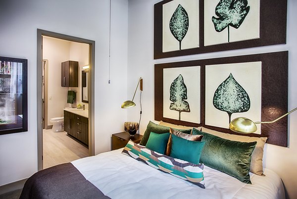 Bedroom featuring elegant decor and large windows at Raleigh at Sloans Lake Apartments, offering luxury living by Greystar