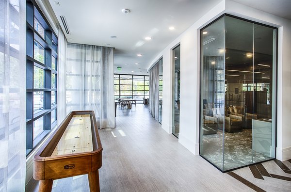 Game room with pool tables and arcade games at Raleigh at Sloans Lake Apartments, ideal for entertainment and social gatherings in luxury living
