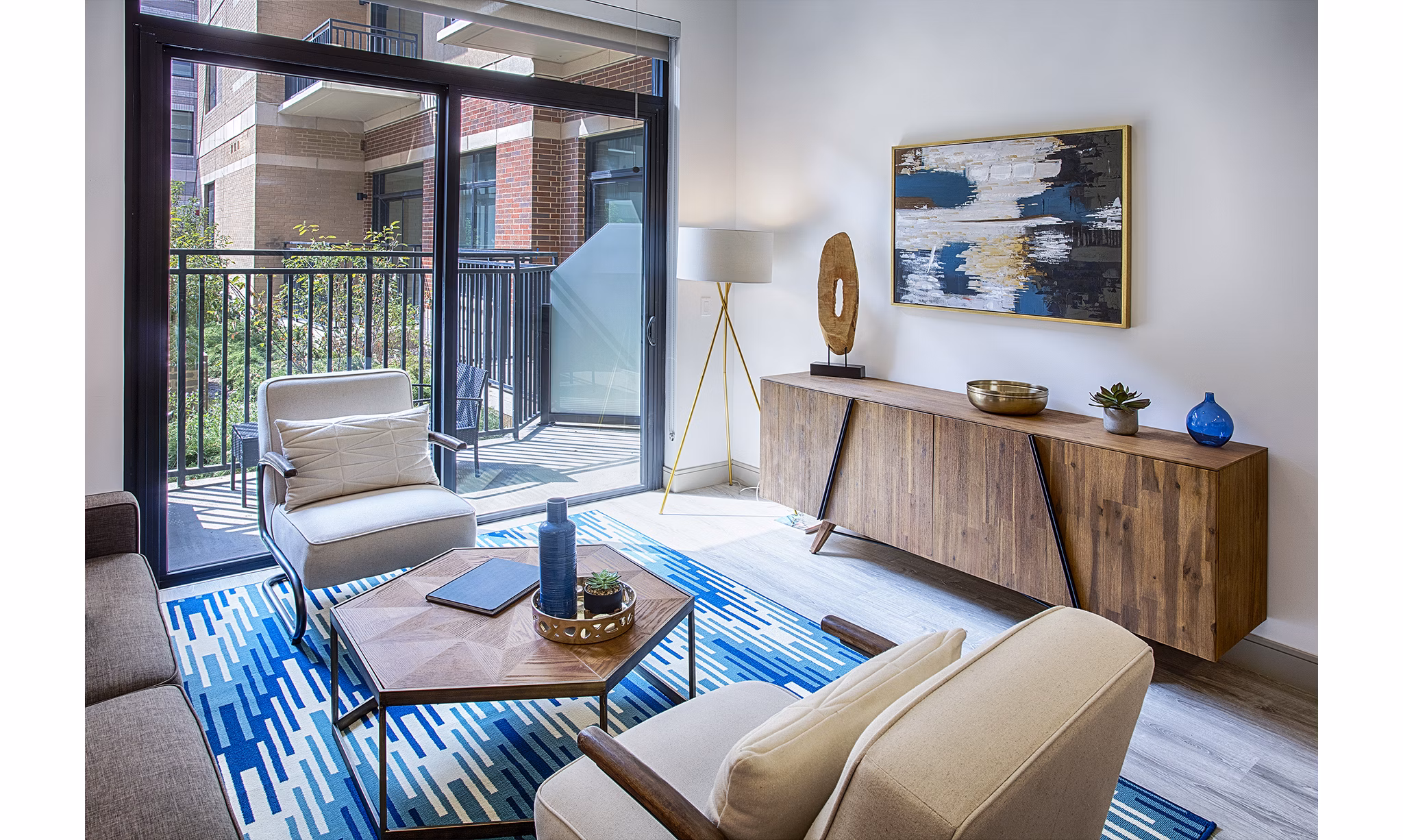 Modern living room with hardwood floors and lake views at Raleigh at Sloans Lake Apartments