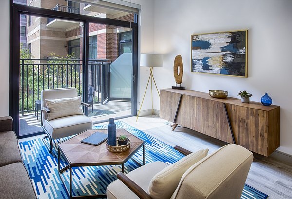 Modern living room with hardwood floors and lake views at Raleigh at Sloans Lake Apartments