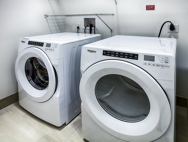 Laundry room equipped with modern washers and dryers at Raleigh at Sloans Lake Apartments