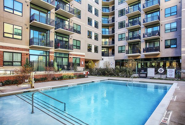 Raleigh at Sloans Lake Apartments: Luxurious pool area with lounge chairs in Greystar luxury apartments, ideal for relaxation and recreation