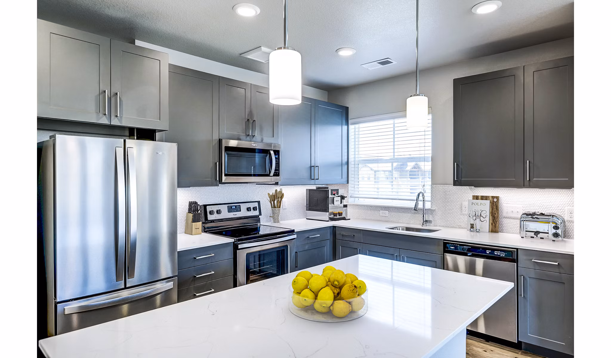 Modern kitchen featuring high-end appliances and granite countertops at The Tenzing Apartments, a luxury living community
