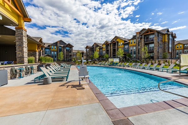 Modern outdoor pool area at The Tenzing Apartments with lounge seating and greenery