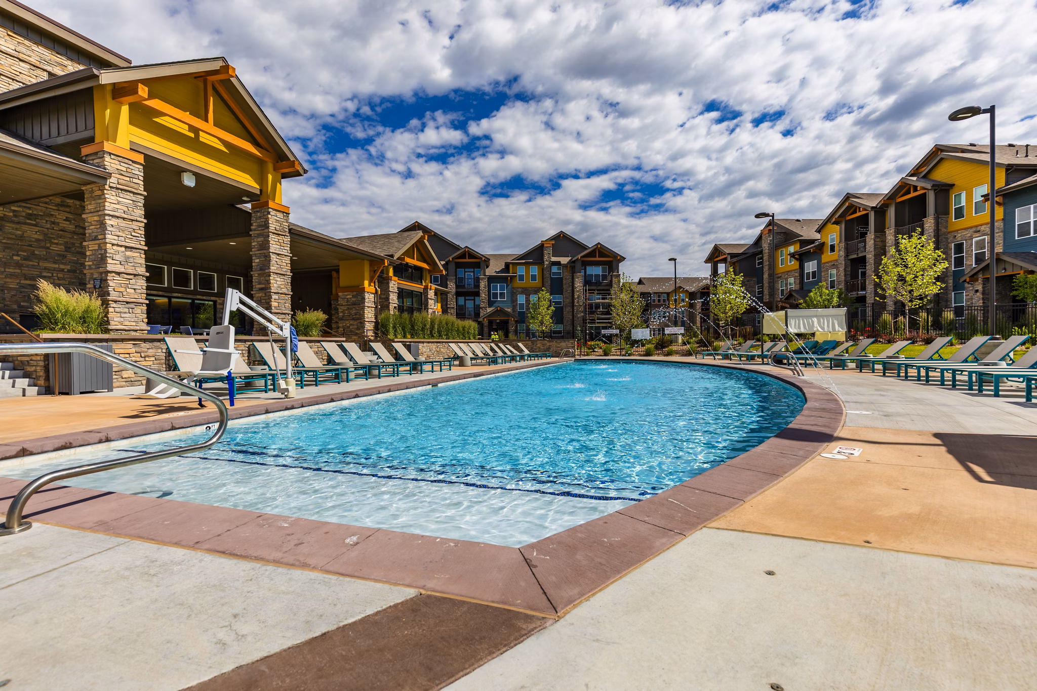 Modern pool area with lounge chairs at The Tenzing Apartments luxury community