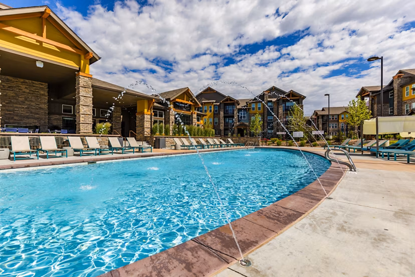 Resort-style pool with lounge seating at The Tenzing Apartments, offering luxury living spaces and amenities